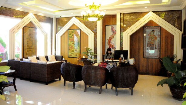 A lobby with a reception desk, dark upholstered sofas, a chandelier, and decorative wall panels. - La Casa Di Bagan Nan Eain Thu (Nyaung-U)