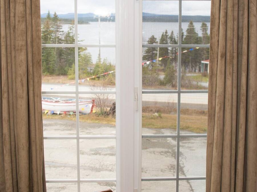 A room with a large window overlooking a body of water and a dock with boats.