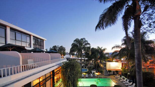 A hotel with a pool, lounge chairs, and palm trees. - Hotel & Spa Villa Vergel (Ixtapan de la Sal)