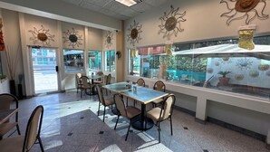 A restaurant interior with a long table, chairs, and decorative sun motifs on the walls.