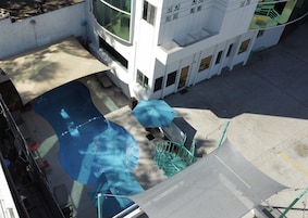 Un edificio moderno con zona de piscina, que incluye un tobogán y una escalera que lleva a un nivel superior.
