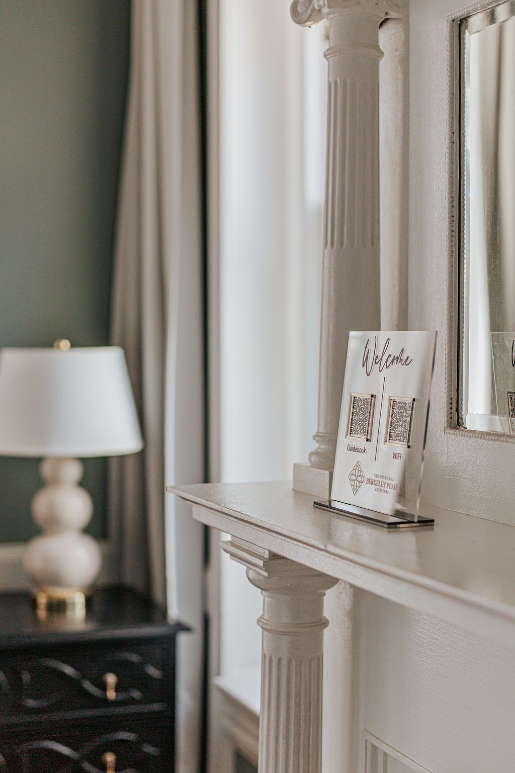 A white reception desk with a sign that reads "Welcome" and a guidebook.