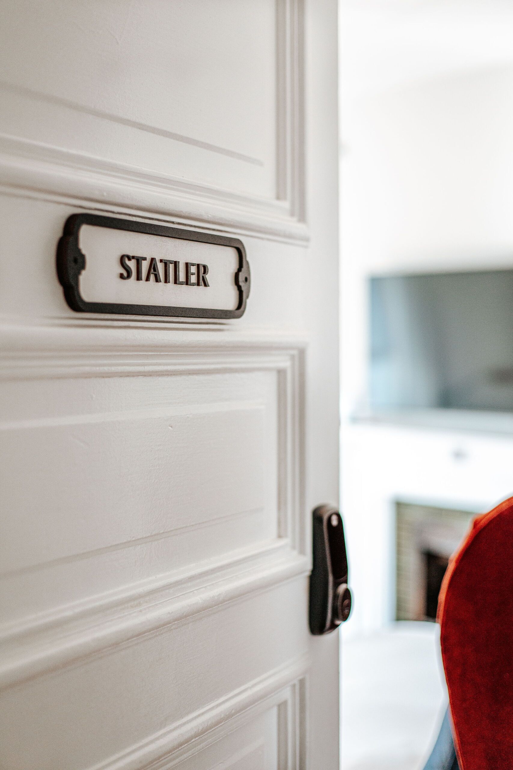 Une porte blanche avec une plaque portant le nom « STATLER » et une poignée de porte noire.