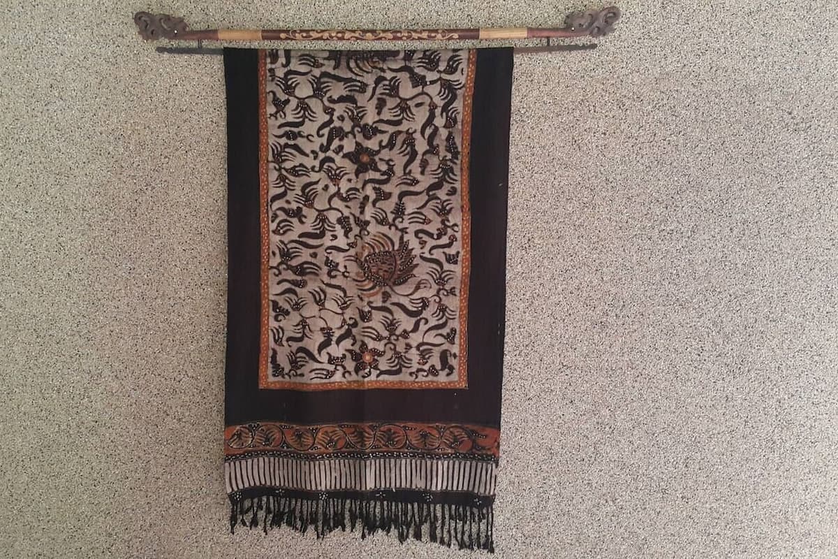 A tapestry hanging on a textured wall.