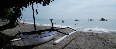 Pantai di sekitar, pasir hitam, dan handuk pantai