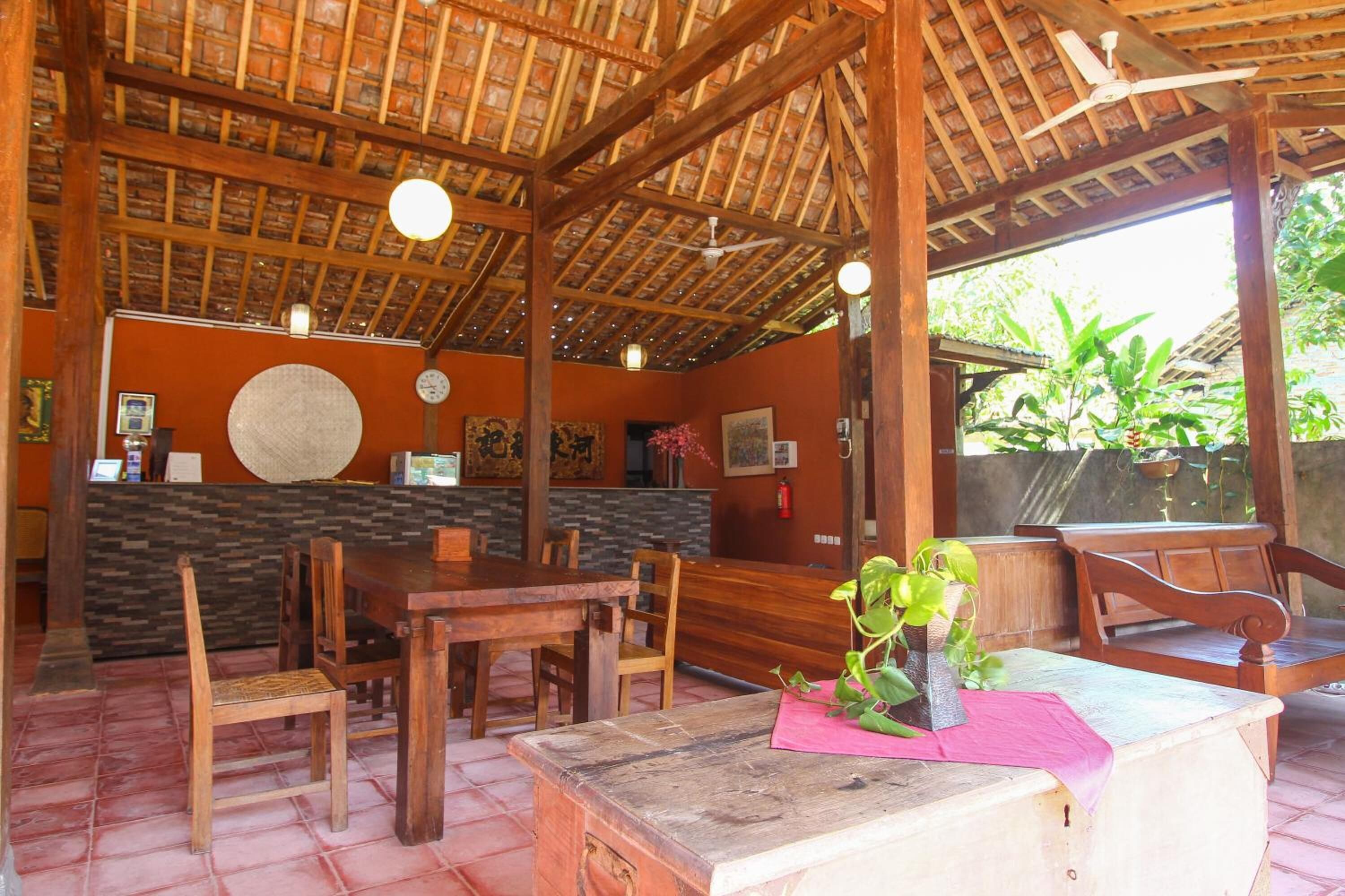 Un interior de madera con mostrador de recepción, sillas de madera y un ventilador de techo.