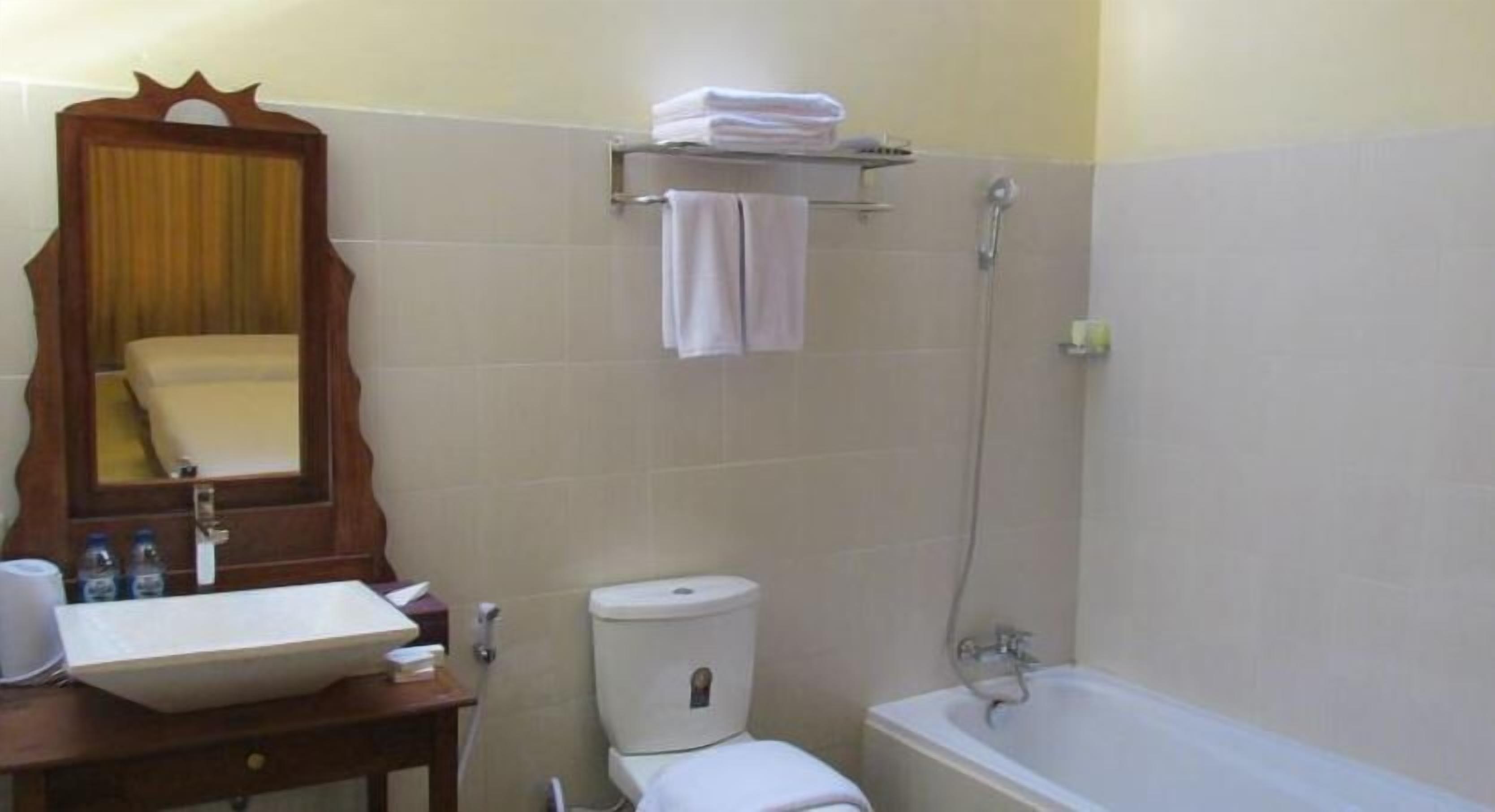Un baño con lavamanos, inodoro y bañera.