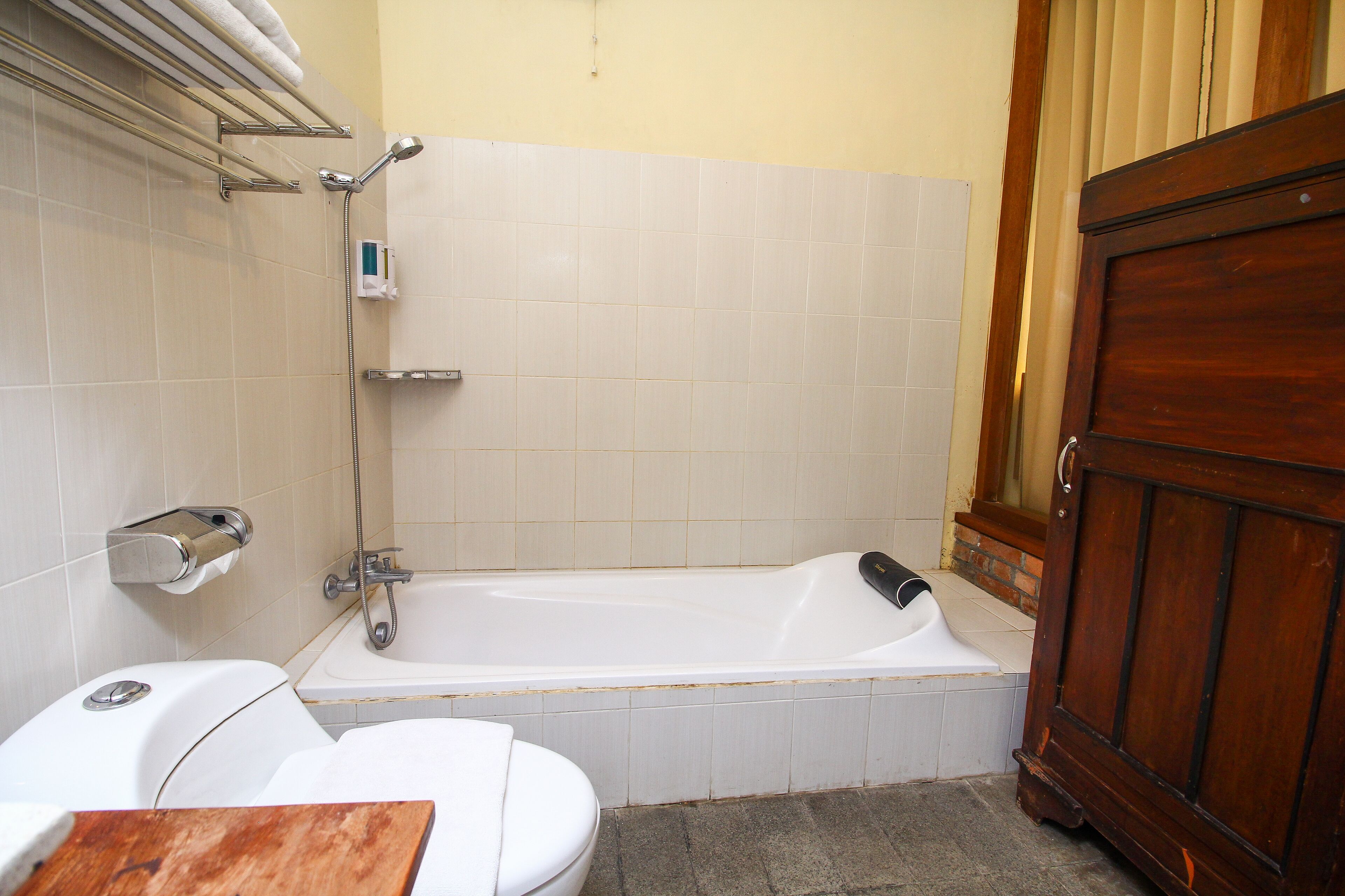 Une salle de bain avec une baignoire, des toilettes et un meuble en bois.