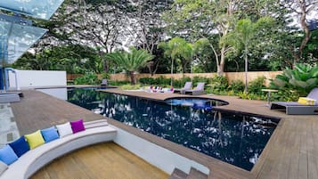 Una piscina al aire libre, tumbonas