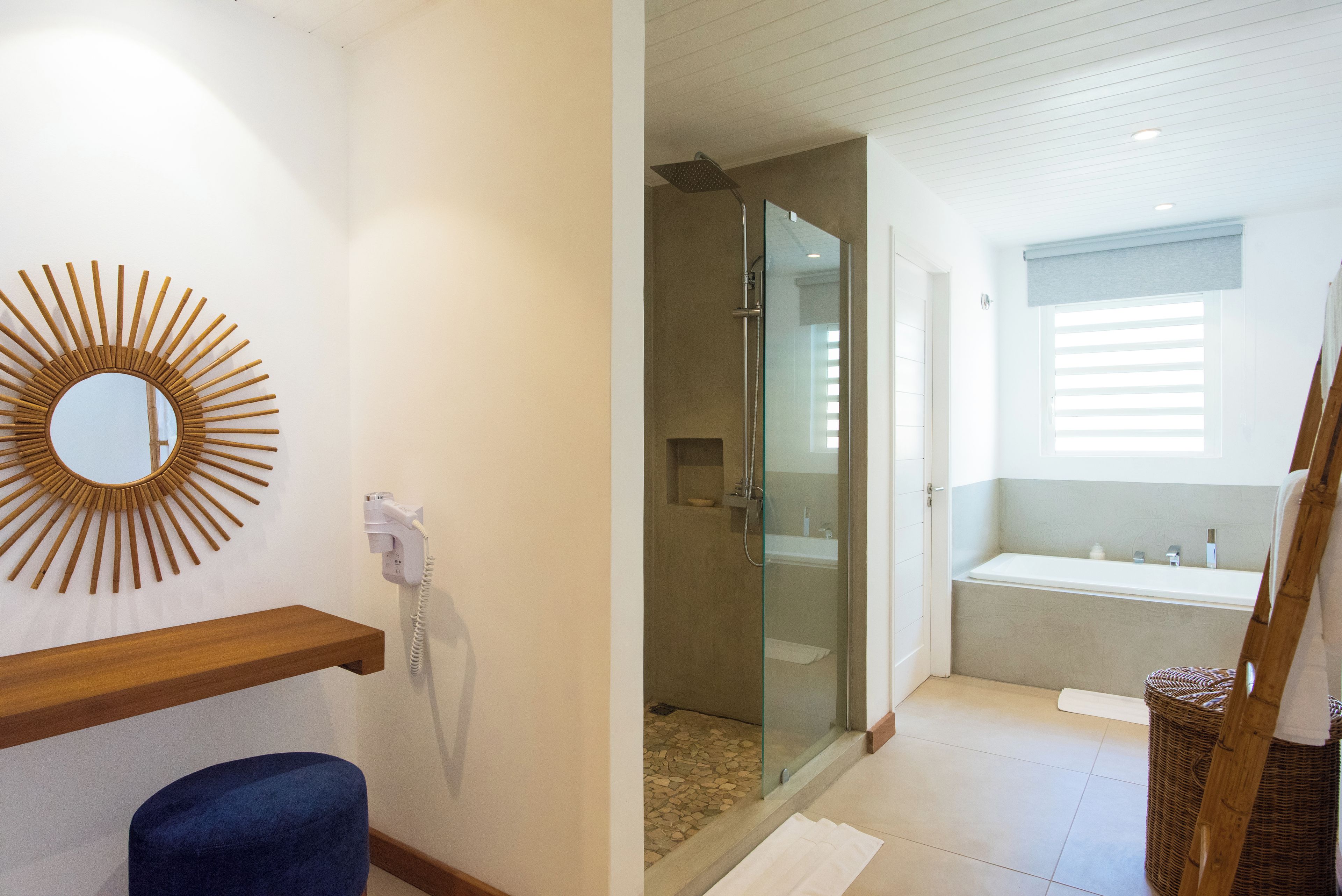 A bathroom with a shower, a bathtub, a mirror, and a towel rack.