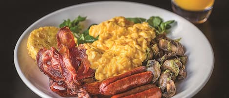 A plate of breakfast food including eggs, sausages, and mushrooms.