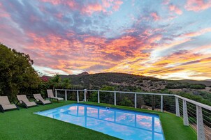 Una piscina al aire libre, sillones reclinables de piscina