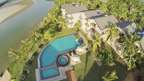 Un resort con una gran piscina, varias construcciones y una playa.