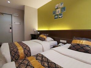 A hotel room with two beds, a desk, a phone, and artwork on the wall. - Star Bay Hotel (Lumut)