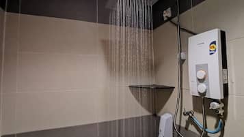 A bathroom with a shower, a hand dryer, and a water heater.