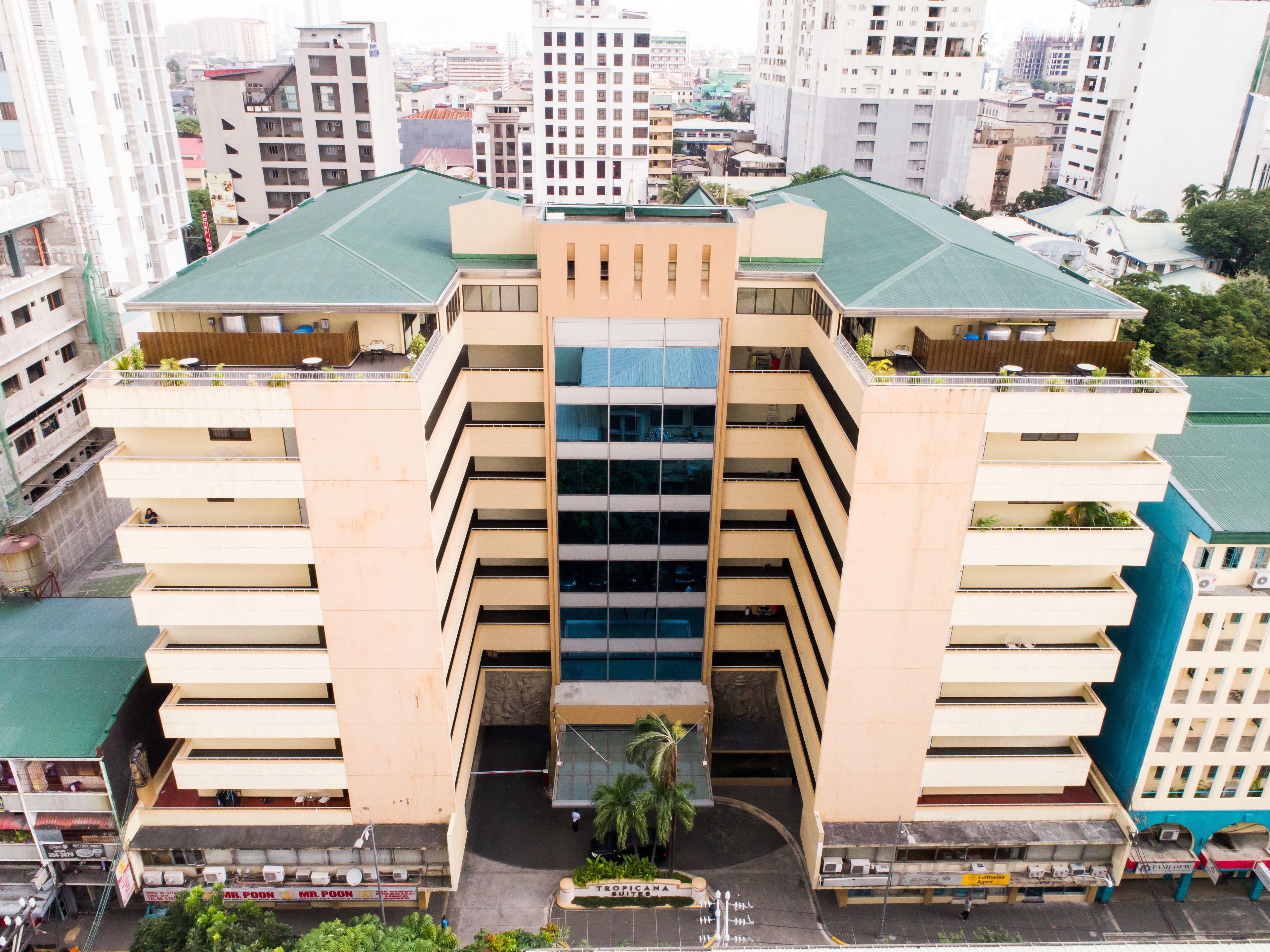 Un immeuble à plusieurs étages doté d’un atrium central, de balcons à chaque étage et d’un toit végétalisé.