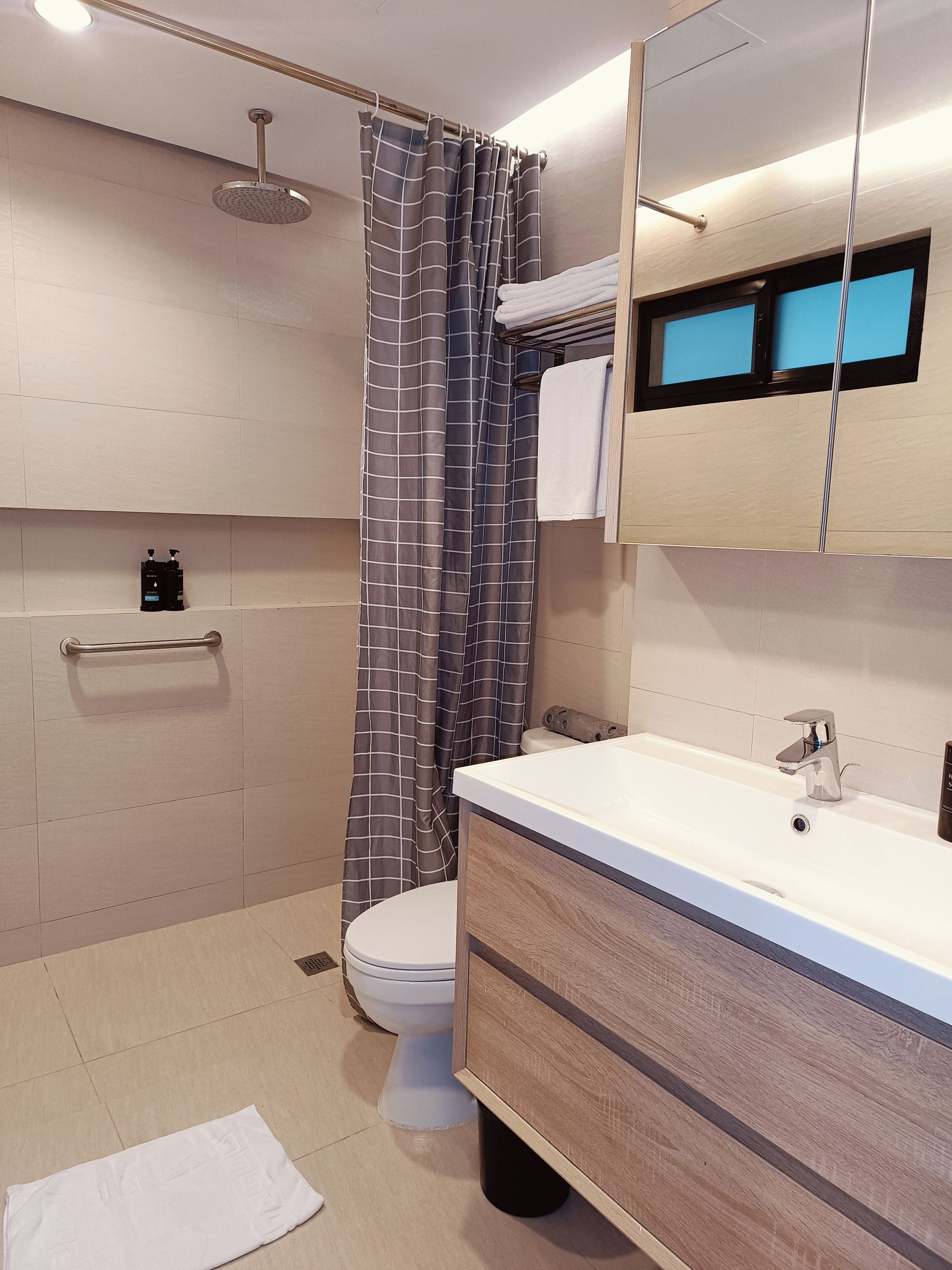A modern bathroom with a shower, toilet, and vanity.