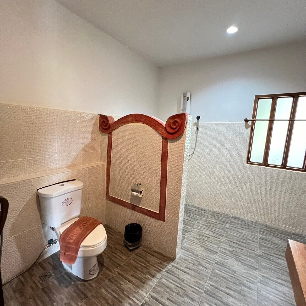 Une salle de bain avec des toilettes, un bidet et une fenêtre.