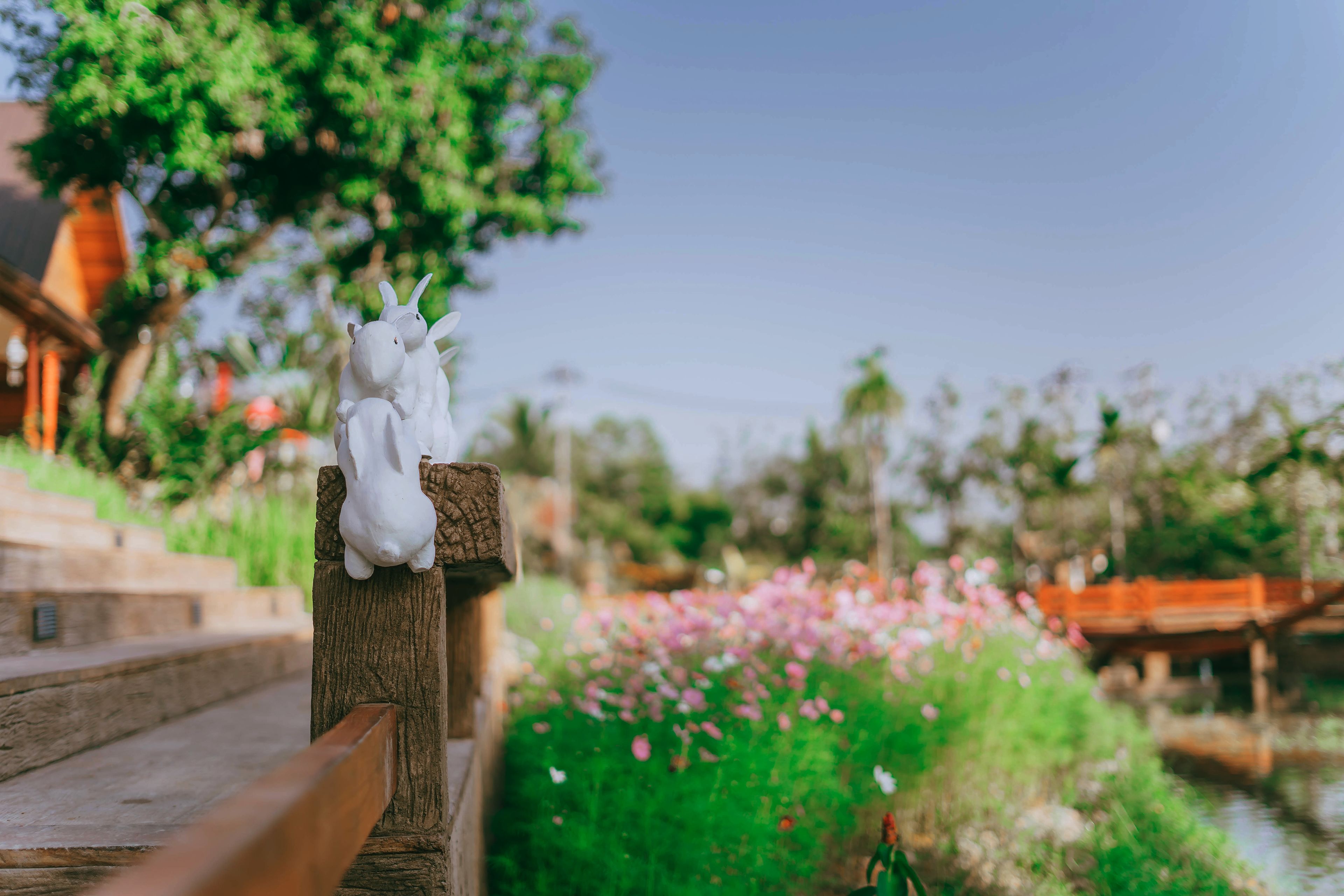 A wooden bench with a white sculpture of a goat.