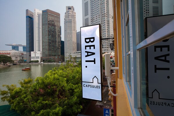 Un paisaje urbano con edificios altos, un río y un cartel que dice 'BEAT Capsules'.