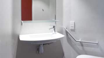 Een moderne badkamer met een wit wastafel, een spiegel en een toilet.