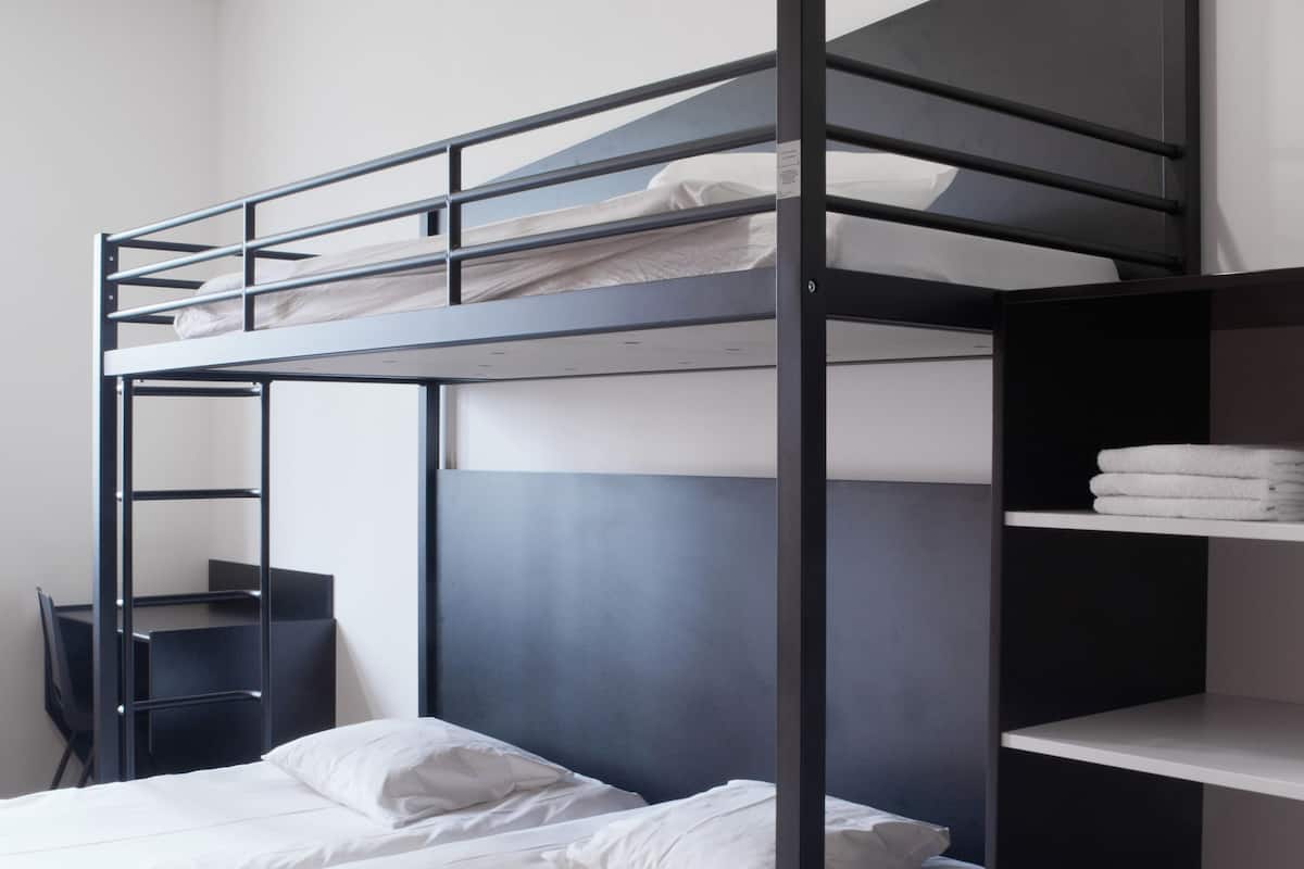 Habitación con literas, escritorio y estanterías.
