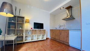 A modern kitchen with white cabinets, a built-in oven, and a stainless steel range hood. - Snow Comfort Edificio Monte Gorbea (Monachil)