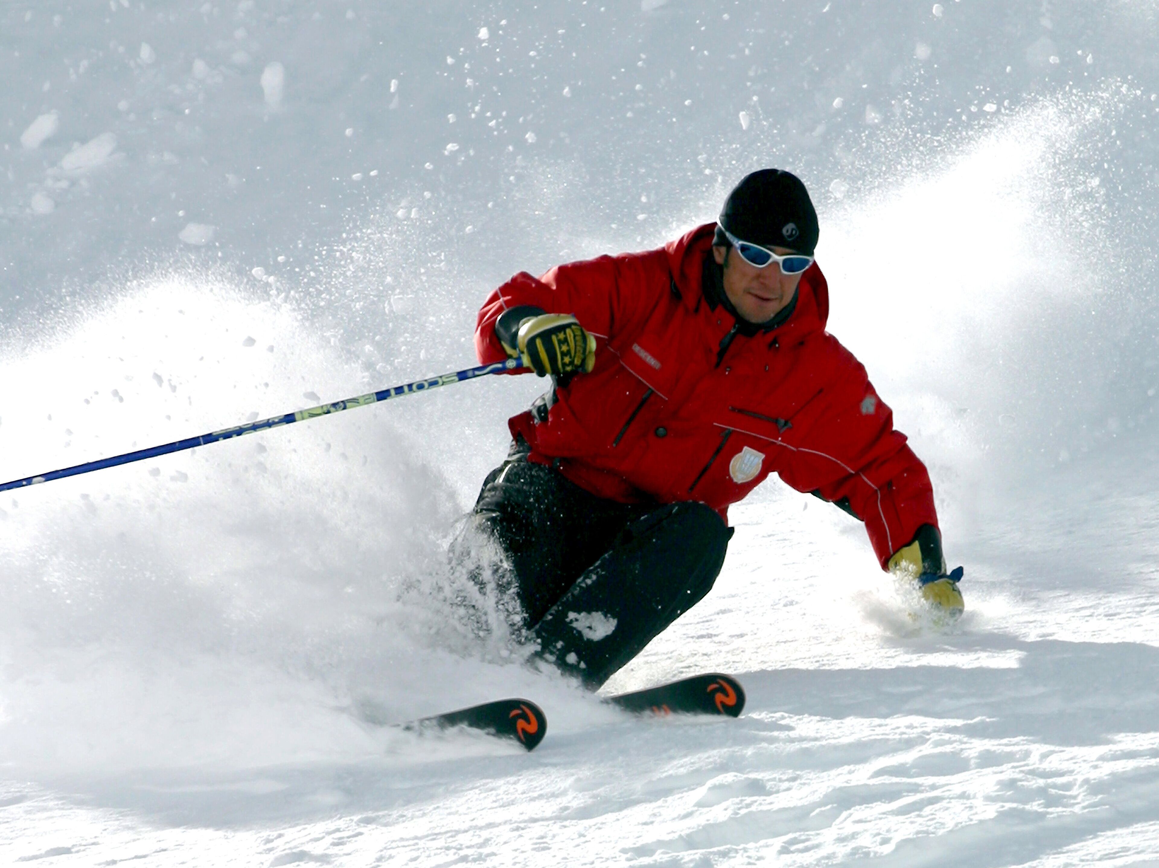 Une personne qui fait du ski sur une pente enneigée.
