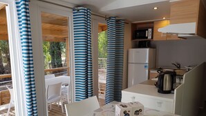 Una cocina compacta equipada con microondas, refrigerador y hervidor.