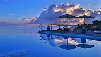 Outdoor pool, an infinity pool, pool umbrellas, pool loungers