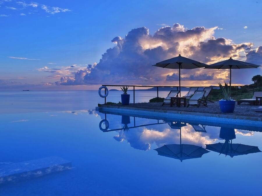 Outdoor pool, an infinity pool, pool umbrellas, sun loungers