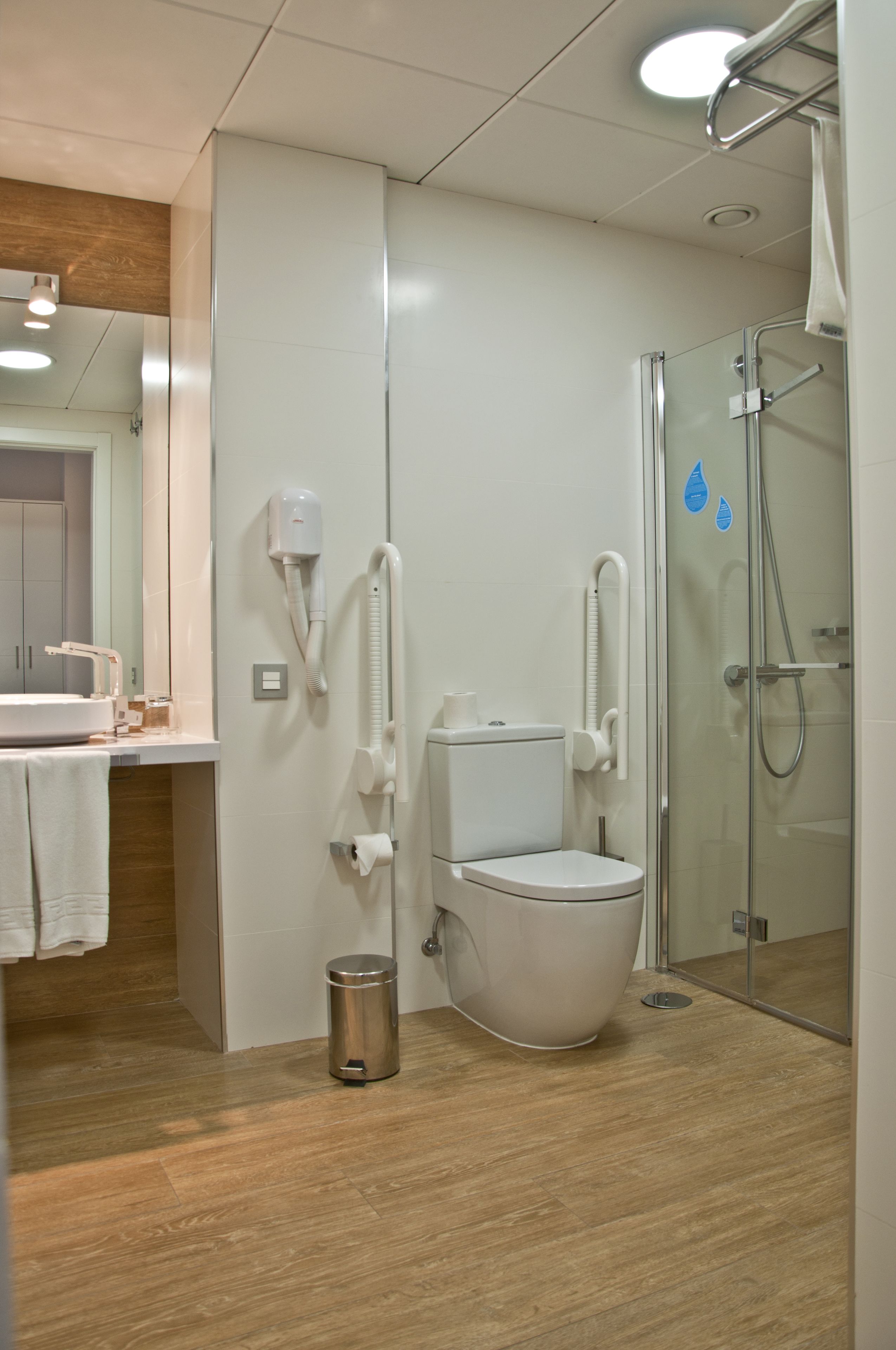 Une salle de bain moderne équipée de toilettes, d’un bidet et d’une douche à parois de verre.