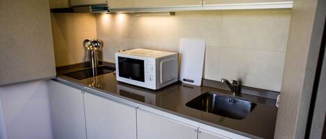A kitchen with a microwave, a sink, and a stovetop.