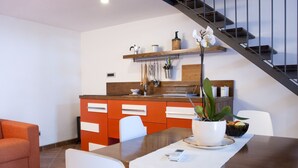 Una cocina moderna con armarios de madera, una mesa de comedor y una escalera.
