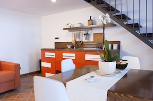 Una cocina moderna con armarios de madera, una mesa de comedor y una escalera.