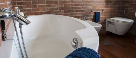 A bathroom with a bathtub, a toilet, and a shower.