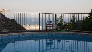 Una piscina con vistas al océano y un crucero en la distancia.
