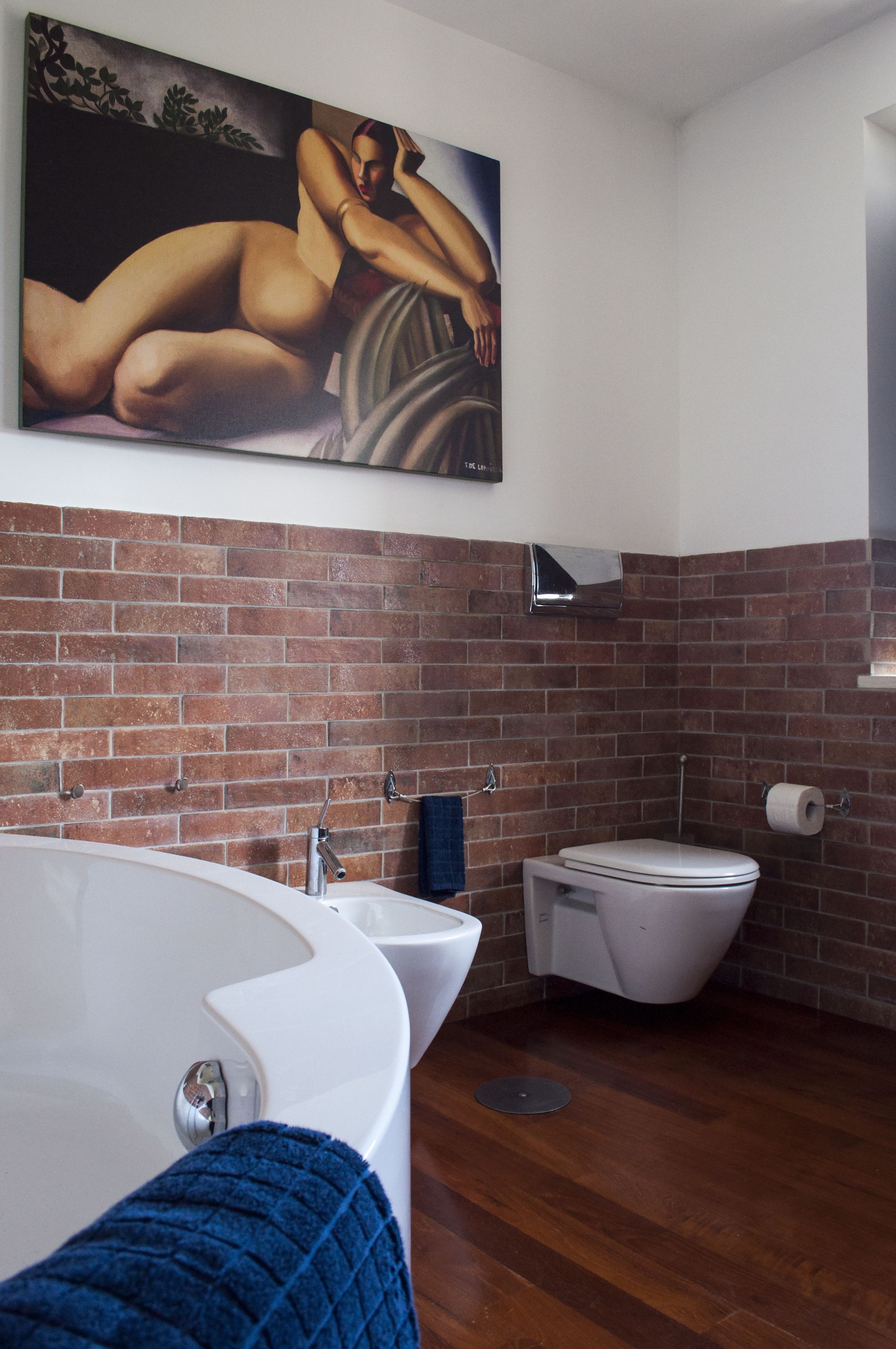 A bathroom with a large bathtub, a toilet, and a shower area.