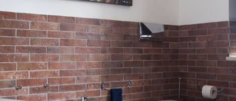A bathroom with a large bathtub, a toilet, and a shower area.