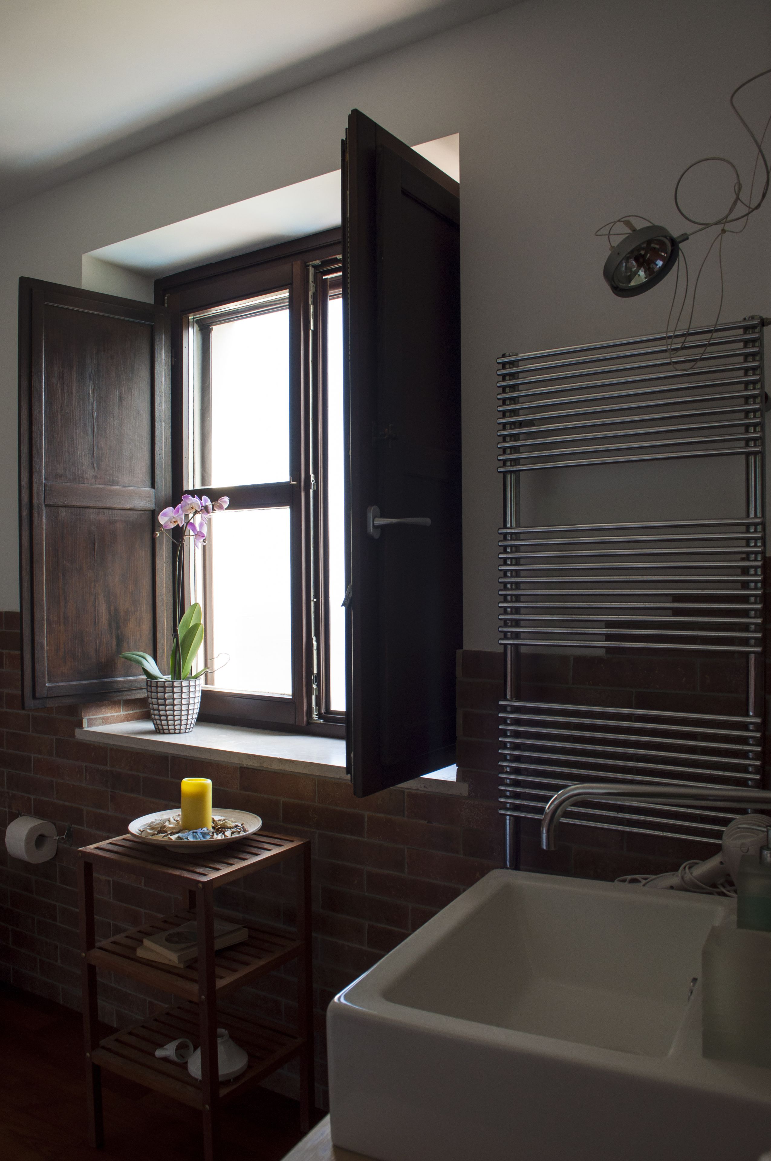 A bathroom with a window, a sink, and a towel rack.