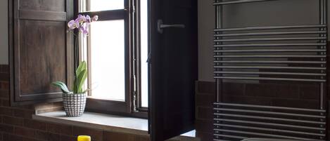 A bathroom with a window, a sink, and a towel rack.