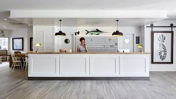 A modern kitchen with a central island, pendant lighting, and a decorative fish on the wall.