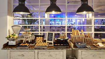 Een buffetopstelling met diverse etenswaren en een bordje met een waarschuwing voor glutenintolerantie.