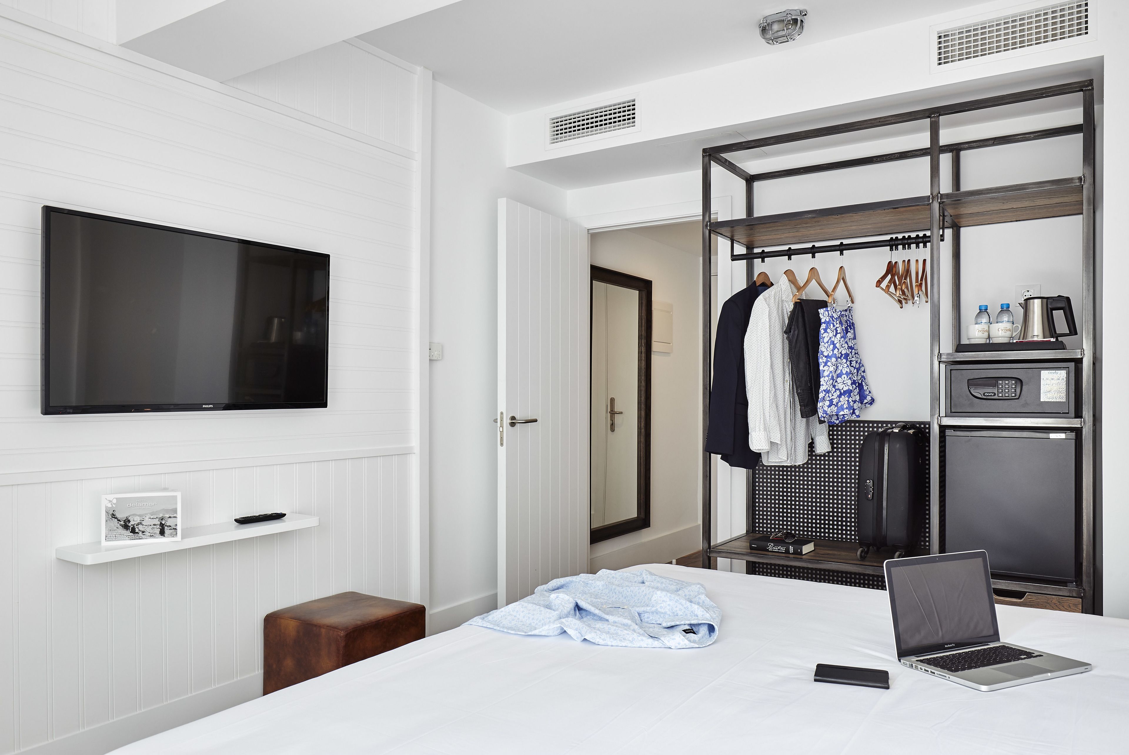 Une chambre d’hôtel équipée d’un lit, d’une télévision, d’une armoire et d’une kitchenette.