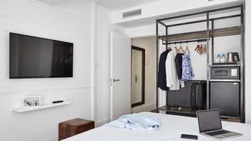 Une chambre d’hôtel équipée d’un lit, d’une télévision, d’une armoire et d’une kitchenette.