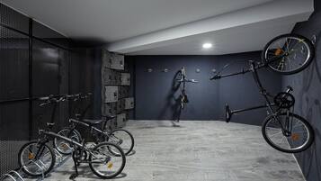 Una habitación con bicicletas, un soporte para bicicletas en la pared y una lámpara en el techo.