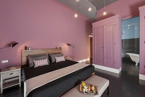 A bedroom with a bed, bedside tables, a bench with breakfast, and a bathroom visible through an open door. - Daniele Manin Guesthouse (Rome)