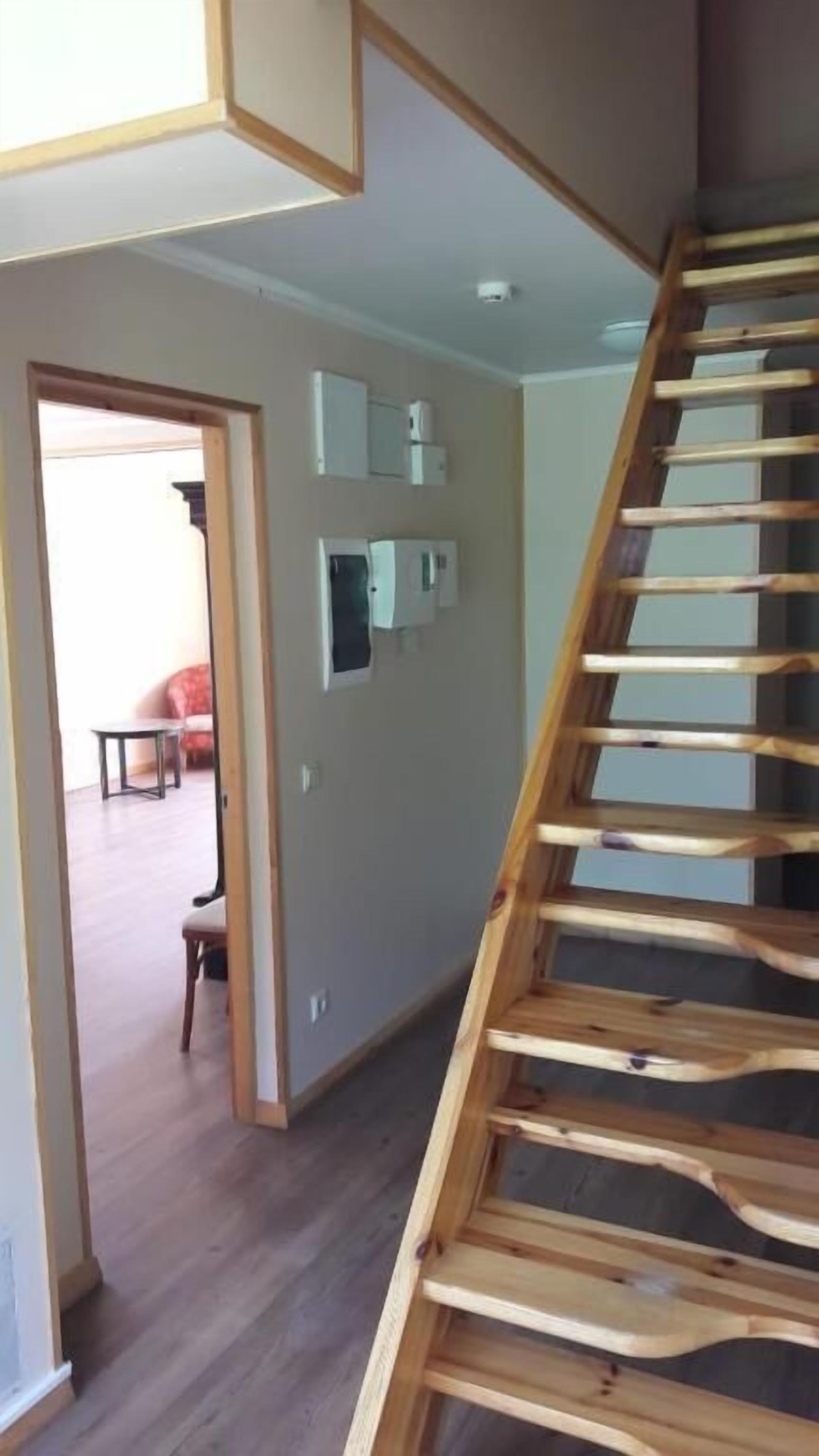 A staircase with a wooden handrail leading to a landing.