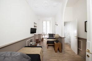 Habitación de hotel con cama, escritorio, silla, un globo terráqueo y televisor.