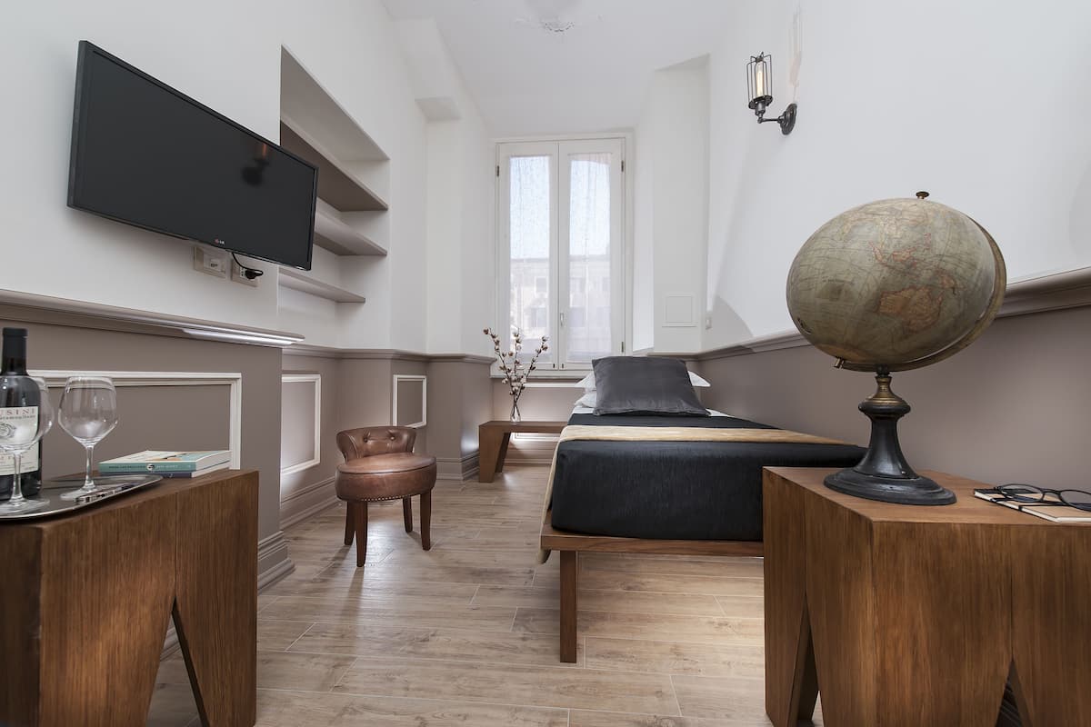 Une chambre à coucher moderne avec un lit, une table de chevet, une lampe et un globe terrestre fixé au mur.